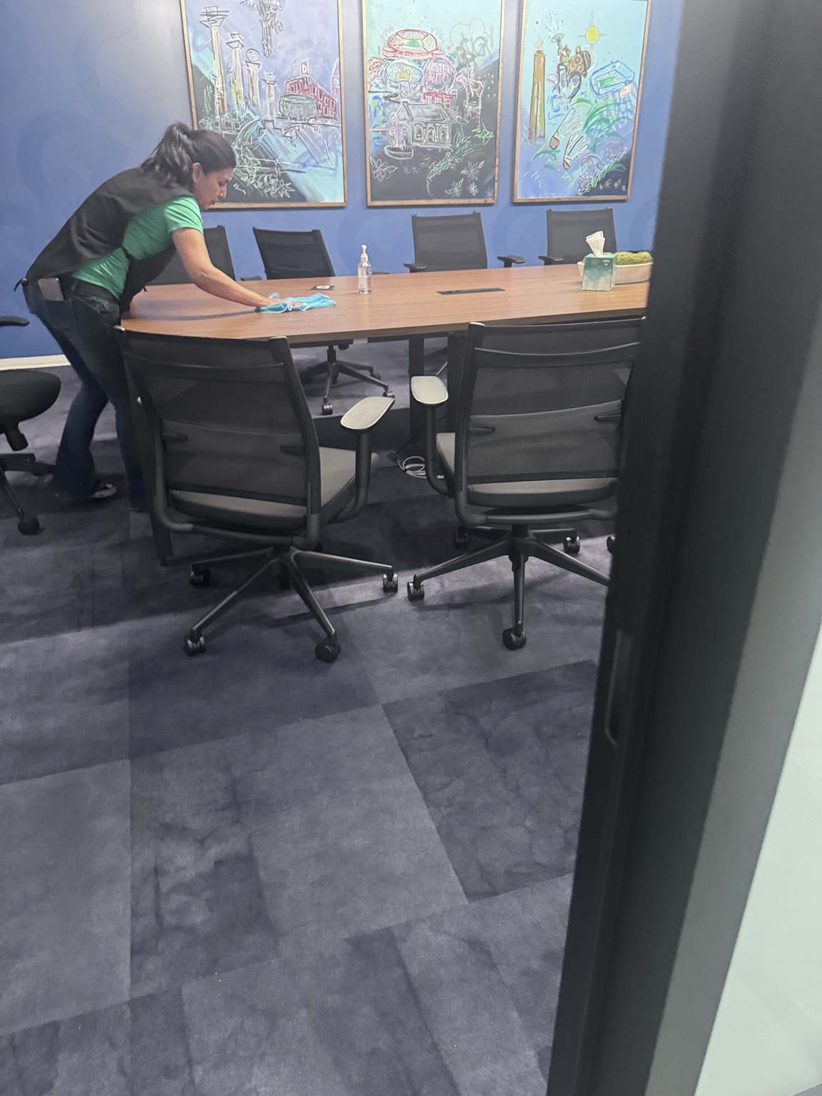 Crew member actively cleaning a commercial conference room